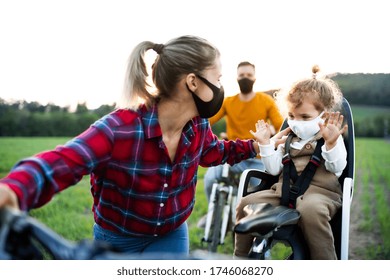 Family With Two Small Children On Cycling Trip, Wearing Face Masks.