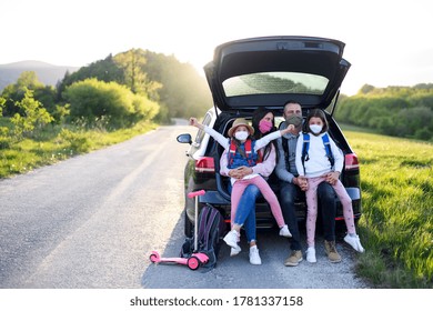 Family With Two Small Daughters On Trip Outdoors In Nature, Wearing Face Masks.