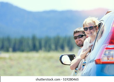 Family Of Two Smiling And Looking Out Of The Car Enjoying Road Trip In California, Vacation Concept