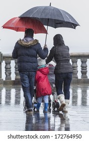 Family With Umbrella Under Rain