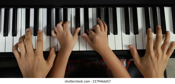 Family Unity Concept Image - Top View Of Piano Player And Child And Father Hands Playing Music.