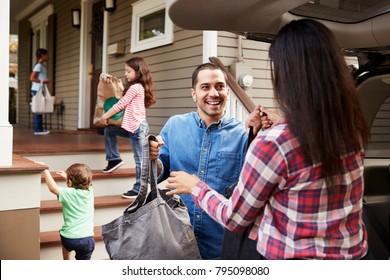 Family Unloading Shopping Bags From Car