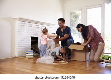 Family Unpacking Boxes In New Home On Moving Day