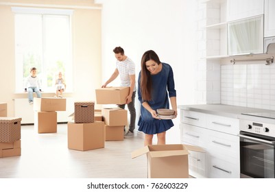 Family Unpacking Boxes In Their New Home