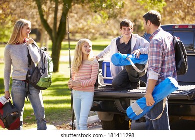 Family Unpacking Pick Up Truck On Camping Holiday