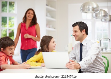 Family Using Digital Devices At Breakfast Table