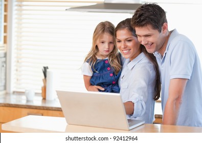 Family Using A Laptop In A Kitchen