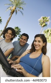 Family Using Laptop Outside