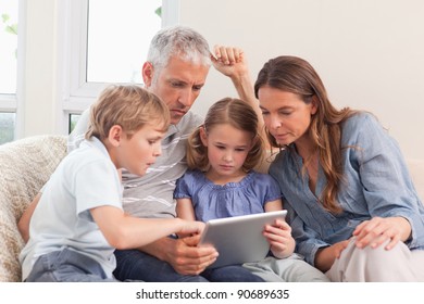 Family using a tablet computer in a living room