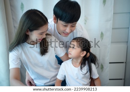 Family vacation, father and mother helping daughter practice in her piano lessons joyfully and happily