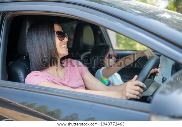 Family vacation
holiday, happy family on a road trip in their car, mom driving car
while her daughter sitting beside, mom and daughter are traveling.
summer ride by
automobile.