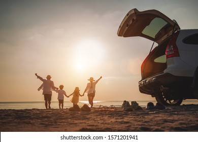 Family vacation holiday, Happy family running on the beach in the sunset. Back view of a happy family on a tropical beach and a car on the side. 