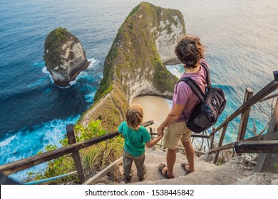 Family Vacation Lifestyle. Happy Father And Son Stand At Viewpoint. Look At Beautiful Beach Under High Cliff. Travel Destination In Bali. Popular Place To Visit On Nusa Penida Island