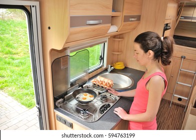 Family Vacation, RV Holiday Trip, Travel And Camping, Happy Smiling Woman Cooking In Camper, Motorhome Interior
