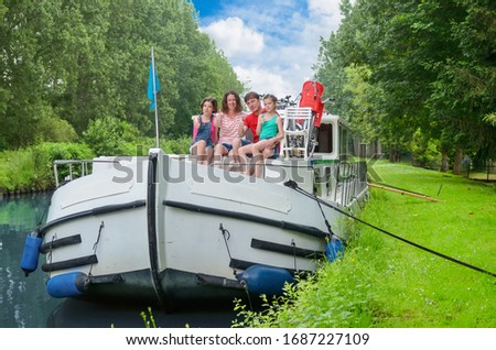 Family vacation, summer holiday travel on barge boat in canal, happy kids and parents having fun on river cruise trip in houseboat in France