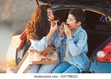 Family Vacation Trip. Snack With Italian Pepperoni Pizza. Mother And Son Having Fun And Eating Pizza Slices In Cat Trunk