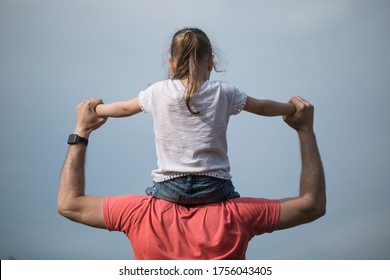 Family values. Father and daughter meet the sunset. He will put the girl on his shoulders and hold her hands. Fathers day concept.