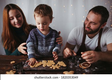 Family Values, Happy Parents, Christmas Time. Mother, Father And Son Making Festive Homemade Gingerbread Cookies