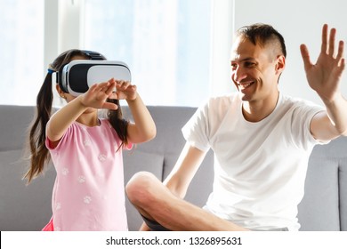 family, virtual reality and entertainment concept - happy father and little daughter with vr glasses playing video game at home in evening  - Powered by Shutterstock