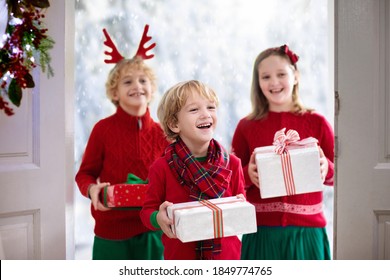 Family Visiting Grandmother On Christmas Day. Kids With Gifts At Home Front Door. Xmas Celebration With Grandparents. Child With Presents At House Entrance. Winter Holiday Celebration. Surprise Visit.