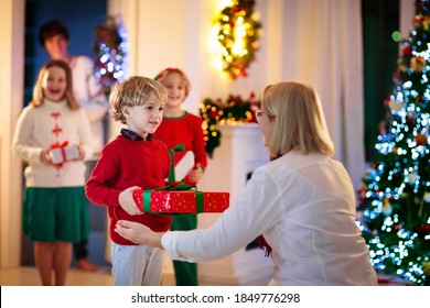 Family Visiting Grandmother On Christmas Day. Kids With Gifts At Home Front Door. Xmas Celebration With Grandparents. Child With Presents At House Entrance. Winter Holiday Celebration. Surprise Visit.