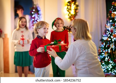 Family Visiting Grandmother On Christmas Day. Kids With Gifts At Home Front Door. Xmas Celebration With Grandparents. Child With Presents At House Entrance. Winter Holiday Celebration. Surprise Visit.