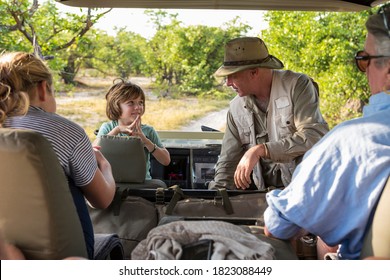 A Family Of Visitors In A Safari Vehicle With A Guide.