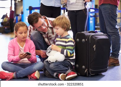 Family Wait In Queue At Airport Check In