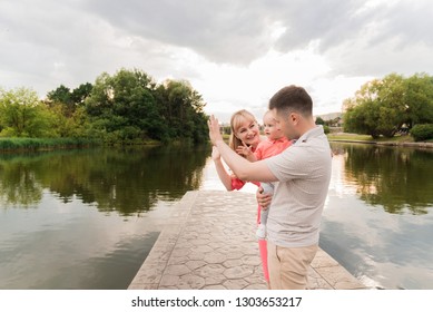 Family Walk In The Park. Family Walks In The Park. Man, Woman And Child In Nature. Picture.