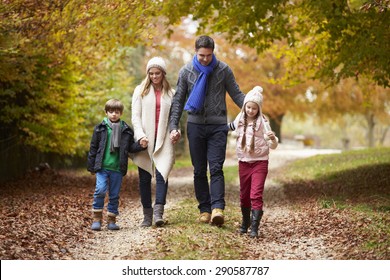 Family Walking Along Autumn Path