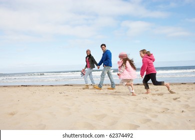 Family Walking Along Winter Beach