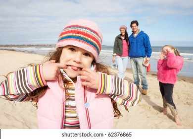 Family Walking Along Winter Beach