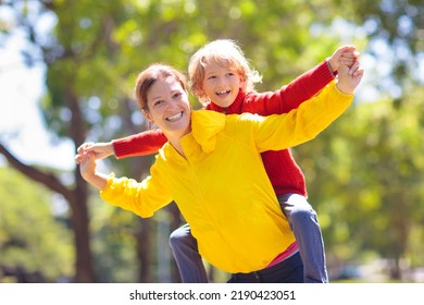 Family Walking In Autumn Park. Kids Play In Sunny Forest. Outdoor Fun. Mother, Father And Children Walk The Dog On Sunny Warm Fall Day. Boy And Girl In Rain Jacket. Parents With Son And Daughter.