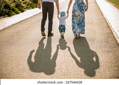 Family walking with baby. image of family's shadows