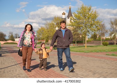 Family Walking With Dog In City Street.