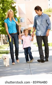 Family Walking With Dog In City Street