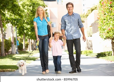 Family Walking With Dog In City Street