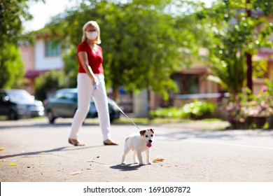 Family Walking Dog During Virus Outbreak. Woman And Child Wearing Face Mask In Coronavirus Lockdown And Quarantine. Home Animal And Pet. Mother And Child With Puppy In Pandemic Or Air Pollution.