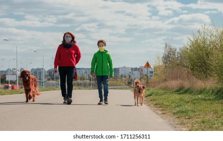 Family Walking Dog During Virus Outbreak. Mother And Son In Masks Walking The Dog Outside The House During Covid-19. Corona Virus Concept