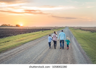 family walking into the sunset