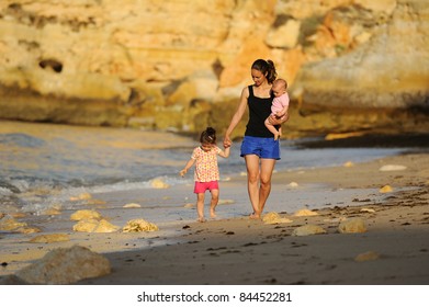 Family Walking On Beach In Algarve Portugal