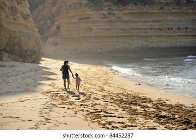 Family Walking On Beach In Algarve Portugal