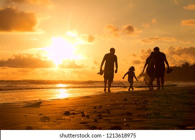 Family Walking On A Beach During Sunset In Costa Rica