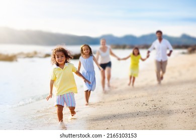 Family Walking On Tropical Beach. Parents And Kids Outdoor. Mother, Father And Children Play, Laugh, Run At Sea Side. Beautiful Young Interracial Couple On Summer Ocean Vacation. Travel With Kids.