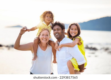 Family walking on tropical beach. Parents and kids outdoor. Mother, father and children play, laugh, run at sea side. Beautiful young interracial couple on summer ocean vacation. Travel with kids. - Shutterstock ID 2293817565