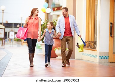 Family Walking Through Mall With Shopping Bags