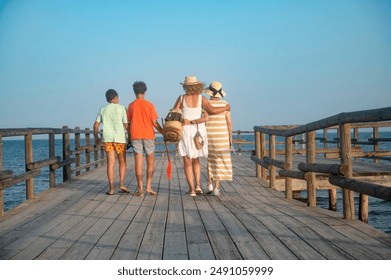 Family walking together on a wooden pier, rear vie - Powered by Shutterstock