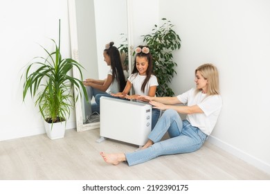 Family Warming Up Near Home Heater At Winter Cold Time. The Symbolic Image Of The Heating Season At Home.