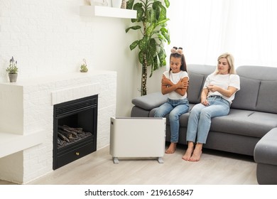 Family Warming Up Near Home Heater At Winter Cold Time. The Symbolic Image Of The Heating Season At Home.