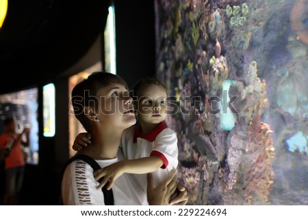 Family watchig fishes at a big aquarium